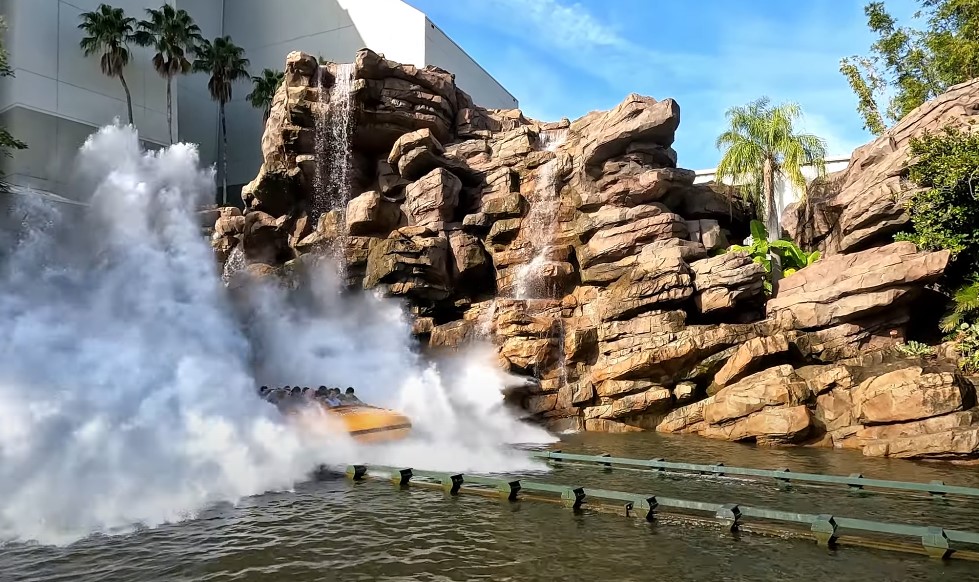 Boat full of people surrounded by water, rocks, and plants