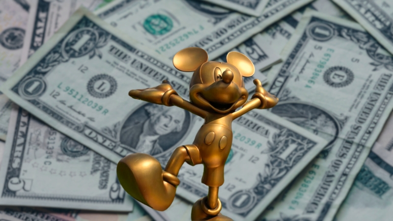 A Gold Mickey Mouse Statue on Top of Dollar Bills