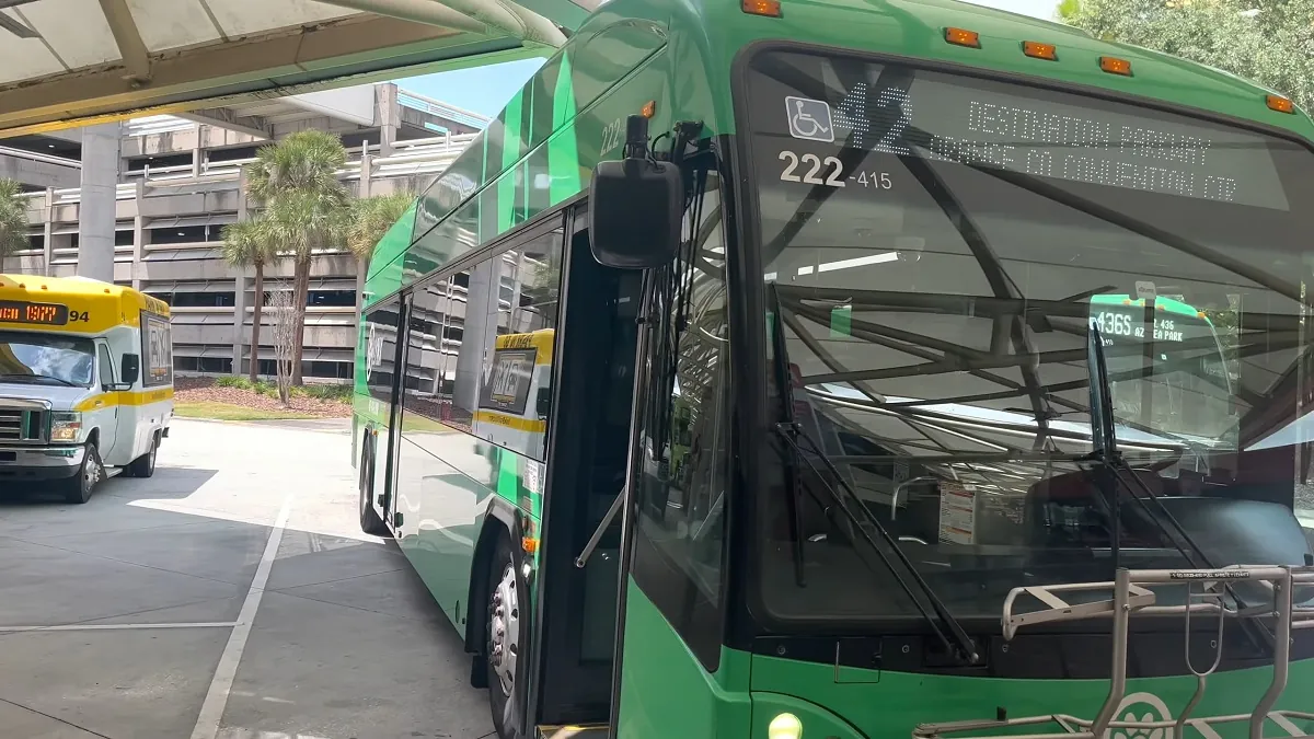 A green public transit bus at an Orlando transportation hub