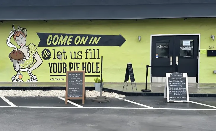 A vibrant storefront, featuring a large graphic of a woman holding a pie